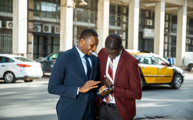Deux personnes regardent ensemble l’écran d’un téléphone
